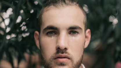 Close-up of a young man with visible tears streaming down his cheeks - higlighting the importance of non-functional requirements in software projects.